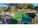 View of a mini golf course, featuring hole number seven, surrounded by lush landscaping and a black seating area at 7673 Heritage Crossing Way # 301, Reunion, FL 34747