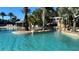 Relaxing pool area featuring clear water, tropical landscaping, and a covered lounge area at 7673 Heritage Crossing Way # 301, Reunion, FL 34747