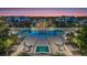 Stunning aerial view showcasing pools, lounge areas, and community buildings surrounded by lush tropical landscaping at 7760 Sandy Ridge Dr # 108, Reunion, FL 34747