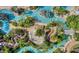Aerial view of a resort-style pool with lazy river, lush landscaping, and many places to lounge at 7760 Sandy Ridge Dr # 108, Reunion, FL 34747