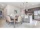 Open layout dining room with modern table set, pendant lighting, and a view into the kitchen area at 7760 Sandy Ridge Dr # 108, Reunion, FL 34747