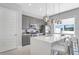 Modern kitchen with a white quartz island, gray cabinets, pendant lights, and a bright window at 7760 Sandy Ridge Dr # 108, Reunion, FL 34747