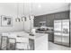Sleek kitchen with stainless steel appliances, gray cabinetry, a quartz island, and pendant lighting at 7760 Sandy Ridge Dr # 108, Reunion, FL 34747
