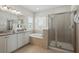 Elegant bathroom featuring double sinks, a soaking tub, and a separate glass-enclosed shower for spa-like experience at 785 Desert Mountain Ct, Reunion, FL 34747