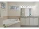 Bathroom with a soaking tub, double vanity, and bright natural light at 785 Desert Mountain Ct, Reunion, FL 34747