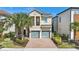Two-story home with a brick driveway, a two-car garage and manicured landscaping at 785 Desert Mountain Ct, Reunion, FL 34747