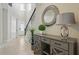 Bright foyer featuring tile floors, modern console table with lamp and round decor mirror, and wrought iron stair railing at 785 Desert Mountain Ct, Reunion, FL 34747