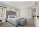 Comfortable main bedroom features a tufted headboard bed, ottoman, and dual closets for ample storage at 785 Desert Mountain Ct, Reunion, FL 34747