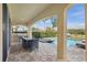 Covered outdoor patio with a barbecue grill and dining area, perfect for entertaining by the pool at 785 Desert Mountain Ct, Reunion, FL 34747