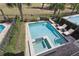 An aerial view showcases a pool with a spa, lounge chairs, and well-maintained landscaping at 785 Desert Mountain Ct, Reunion, FL 34747