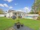 Backyard featuring lush green grass, a pool with lounge chairs, and an outdoor kitchen area perfect for entertaining at 7924 Coot St, Orlando, FL 32822