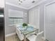 Bright dining room featuring a modern glass table with white chairs and a view of the white pantry doors at 7924 Coot St, Orlando, FL 32822