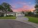 Charming one-story home with a well-manicured lawn and a circular driveway on a cul-de-sac, captured at dusk at 7924 Coot St, Orlando, FL 32822