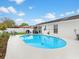 Backyard swimming pool with outdoor kitchen area, a white privacy fence, and lush landscaping for an entertainer's dream at 7924 Coot St, Orlando, FL 32822