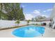 Backyard with a sparkling swimming pool surrounded by landscaping and a white fence, perfect for privacy and relaxation at 7924 Coot St, Orlando, FL 32822