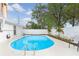 A beautiful swimming pool surrounded by white fencing, lush landscaping, and mature trees for added privacy at 7924 Coot St, Orlando, FL 32822
