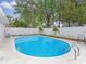 Sparkling blue swimming pool surrounded by a white fence, landscaping, and lush greenery for a relaxing outdoor oasis at 7924 Coot St, Orlando, FL 32822