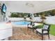 Outdoor entertainment area with covered patio, an outdoor kitchen, a sparkling pool, and stylish patio furniture at 7924 Coot St, Orlando, FL 32822