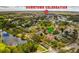 An aerial view of a neighborhood with lush green trees, streets, and community amenities including a lake at 808 Golfpark Dr, Celebration, FL 34747