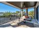 Outdoor covered balcony with comfortable lounge furniture and views of palm trees and blue skies at 808 Golfpark Dr, Celebration, FL 34747