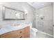 Well-lit bathroom with vanity, tiled walk-in shower with glass door, and modern fixtures, offering comfort and style at 808 Golfpark Dr, Celebration, FL 34747