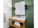 Stylish powder room with a wood vanity, marble countertop, modern fixtures, and trendy green textured wallpaper at 808 Golfpark Dr, Celebration, FL 34747