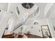 Soaring foyer with a winding staircase, hardwood floors, and statement lighting at 808 Golfpark Dr, Celebration, FL 34747