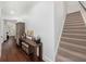 Hallway leading to staircase with wood floors, small desk, and decor at 808 Golfpark Dr, Celebration, FL 34747