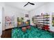 Bright living room with hardwood floors, natural light from windows, and shelving for books and collectibles at 808 Golfpark Dr, Celebration, FL 34747