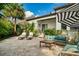 Charming patio featuring a cozy seating area, lush landscaping, and a shaded umbrella at 808 Golfpark Dr, Celebration, FL 34747