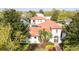 An aerial view of a Mediterranean-style home with a red tile roof surrounded by lush greenery at 8437 Lake Burden Cir, Windermere, FL 34786