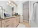 Bathroom vanity with marble countertops and a door leading to a shower and plush white rug at 8437 Lake Burden Cir, Windermere, FL 34786