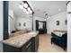 Spacious primary bathroom with black vanities, granite countertop, mirrors, and separate bathtub at 8437 Lake Burden Cir, Windermere, FL 34786