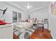 Well-lit bedroom featuring white walls, hardwood floors, a large window, and a plush rug at 8437 Lake Burden Cir, Windermere, FL 34786