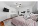 Stylishly furnished bedroom with a plush bed, elegant dresser, ceiling fan, and wood floors at 8437 Lake Burden Cir, Windermere, FL 34786