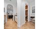 Hallway featuring an arched doorway leading to the kitchen and half-bath with tile flooring at 8437 Lake Burden Cir, Windermere, FL 34786