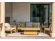 Covered patio with stylish outdoor furniture, including a sofa, chairs, and a fire pit table at 8437 Lake Burden Cir, Windermere, FL 34786