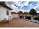 Outdoor patio with brick flooring, two white Adirondack chairs, and a wall with an iron fence at 8437 Lake Burden Cir, Windermere, FL 34786