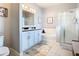 Bright bathroom featuring a double vanity, soaking tub, and a glass-enclosed shower at 9158 Elsa Ct, Davenport, FL 33897