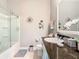 Bright bathroom featuring granite countertops, vanity, and shower with glass doors at 9158 Elsa Ct, Davenport, FL 33897