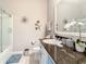 Bright bathroom featuring granite countertops, vanity, and shower with glass doors at 9158 Elsa Ct, Davenport, FL 33897
