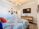 Bedroom featuring a dresser and TV and complemented by decorative wall mirrors at 9158 Elsa Ct, Davenport, FL 33897