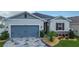 Charming single-Gathering home with a blue garage door, stone accents, and decorative landscaping at 9158 Elsa Ct, Davenport, FL 33897