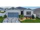 Charming single-Gathering home with a blue garage door, stone accents, and decorative landscaping at 9158 Elsa Ct, Davenport, FL 33897