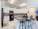 Spacious kitchen features white cabinets, black appliances, an island with barstool seating, and stylish backsplash at 9158 Elsa Ct, Davenport, FL 33897