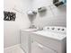 Well-lit laundry room with a modern washer, dryer and shelving at 9158 Elsa Ct, Davenport, FL 33897