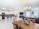 Open-concept living area featuring a dining table, kitchen island, and comfortable seating, perfect for modern living at 9158 Elsa Ct, Davenport, FL 33897