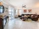 Comfortable living room features a leather sofa, ceiling fan and view of the outdoor patio at 9158 Elsa Ct, Davenport, FL 33897