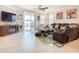 Cozy living room featuring a comfortable leather sofa, TV, and access to the pool area at 9158 Elsa Ct, Davenport, FL 33897