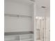 Bright closet space with shelving and hanging rod, and an open door to a bathroom with neutral tones at 10287 Ebb Tide Lane, Orlando, FL 32821